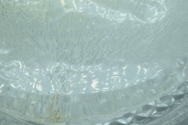 dsfocused Pure transparent rectangular ice block with air bubbles on purpure background.