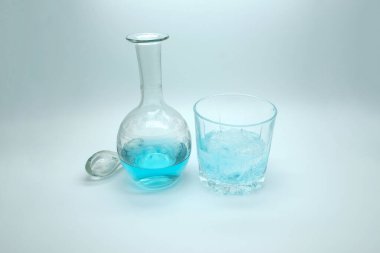 Sürahide mavi alkollü içecek. Beyaz arka planda mavi cini olan kokteyl