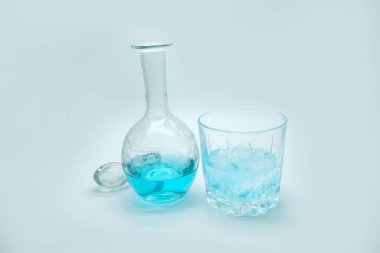 Sürahide mavi alkollü içecek. Beyaz arka planda mavi cini olan kokteyl