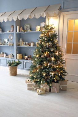 Noel, Yeni Yıl dekore edilmiş Noel hediyeleri kurdelelerle süslenmiş, fincanlar ve şekerlemelerle dolu masa ve beyaz, gümüş ve pembe toplarla süslenmiş Noel ağacı.