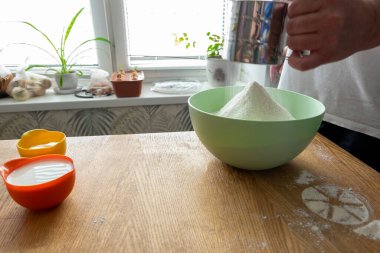 Ağ süzgeci aşçının elinde çalışıyor. Bedava metin alanı olan arkaplan. Mantı için hamur hazırlığı. Hamur ve hamur işlerinin adım adım tarifi.