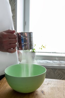 Ağ süzgeci aşçının elinde çalışıyor. Bedava metin alanı olan arkaplan. Mantı için hamur hazırlığı. Hamur ve hamur işlerinin adım adım tarifi.