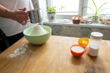 Ağ süzgeci aşçının elinde çalışıyor. Bedava metin alanı olan arkaplan. Mantı için hamur hazırlığı. Hamur ve hamur işlerinin adım adım tarifi.