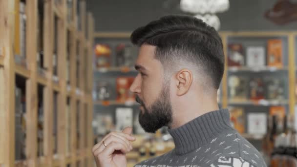 Jóképű szakállas férfi mosolyog a kamerába, miközben a szupermarketben vásárol. — Stock videók