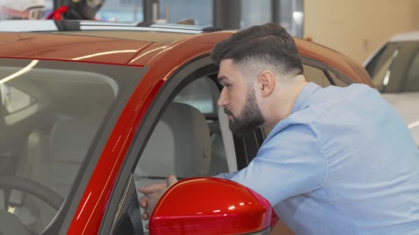 Homme client souriant à la caméra tout en examinant la nouvelle voiture en vente — Video