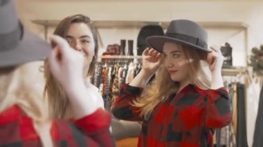 Moda mağazasında alışveriş yapan bayan arkadaşlar.