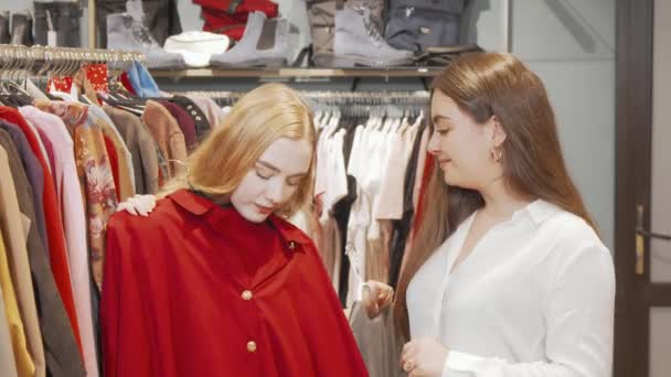Γυναίκες φίλες δοκιμάζουν καινούρια ρούχα στο κατάστημα μόδας — Αρχείο Βίντεο