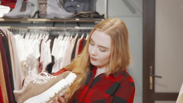 Glückliche junge Frau lächelt beim Schuhkauf in die Kamera — Stockvideo