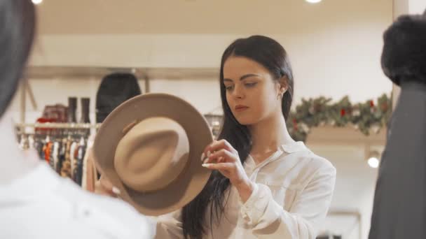 Belle femme essayant chapeau au magasin de mode — Video