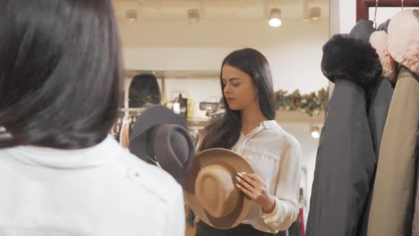 Atraktivní žena zkouší klobouky před zrcadlem — Stock video