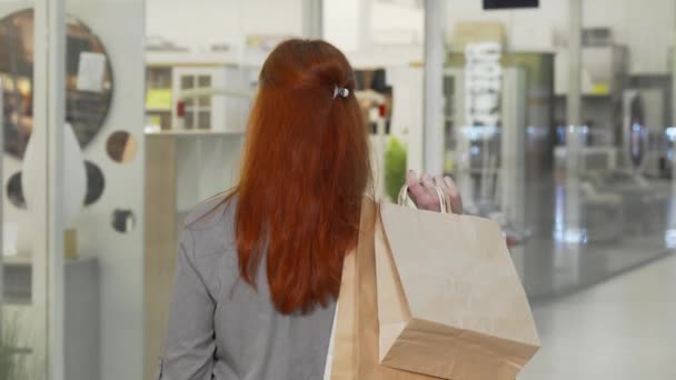 Onnellinen nainen hymyilee kameralle ostoksilla ostoskeskuksessa — kuvapankkivideo