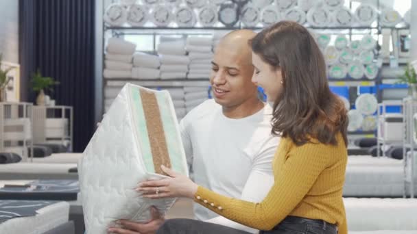 Giovane coppia sceglie un nuovo materasso da acquistare nel negozio di arredamento — Video Stock