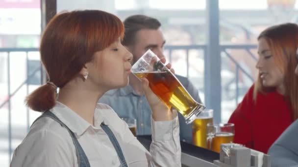 Urocza kobieta uśmiecha się do kamery pijąc pyszne piwo — Wideo stockowe