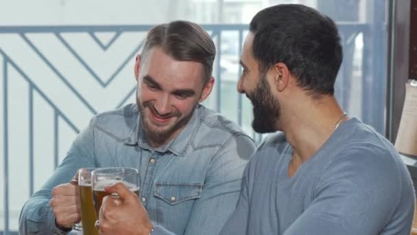 Heureux mâle amis clinking bière verres appréciant boire à l 'pub — Video