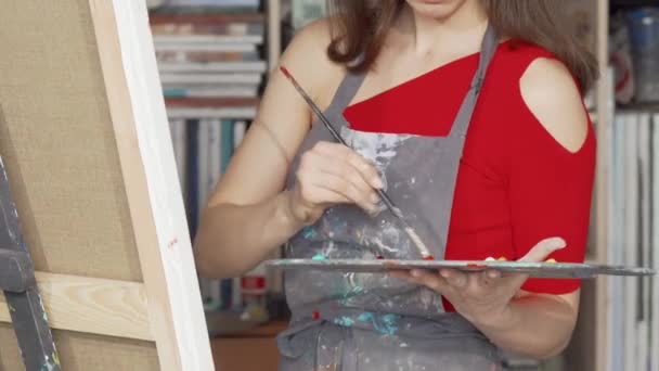Розсувний знімок красивої молодої жінки, що малює в художній студії — стокове відео