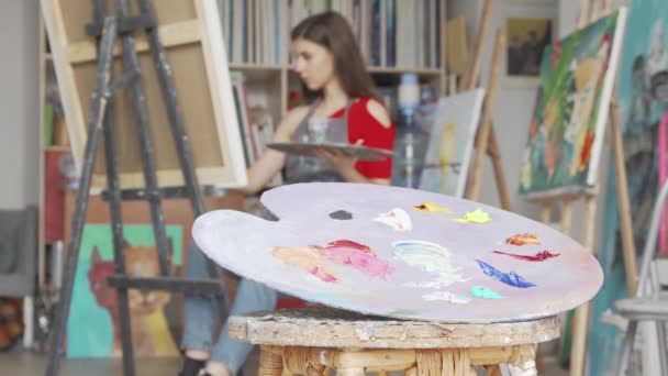 Focus sélectif sur une palette au studio d'art d'une jeune artiste féminine — Video