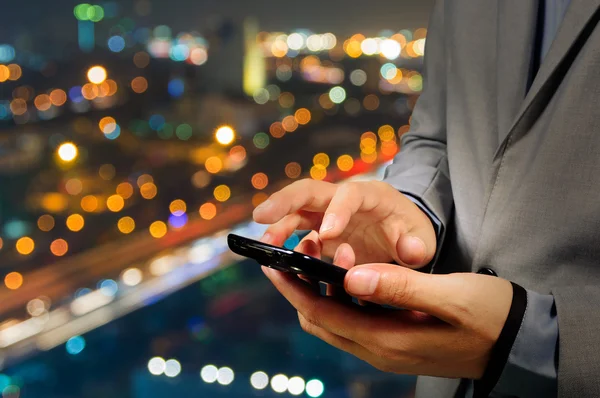 Hombre de negocios guapo en la ciudad usando su teléfono inteligente . —  Fotos de Stock