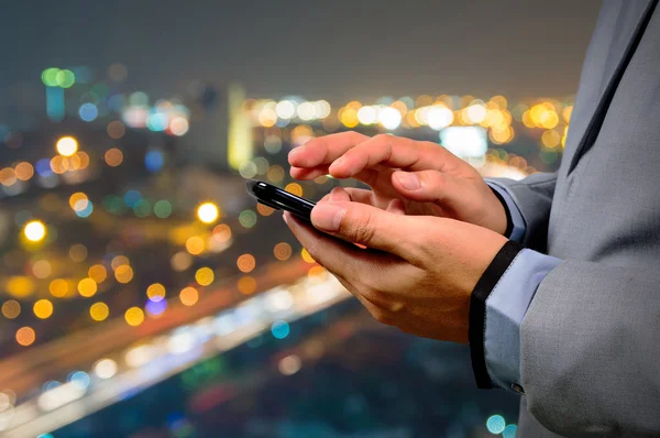 Hombre de negocios guapo en la ciudad usando su teléfono inteligente . —  Fotos de Stock