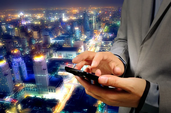 Empresário usar Mobilephone ou Smartphone com Modern City Backg — Fotografia de Stock