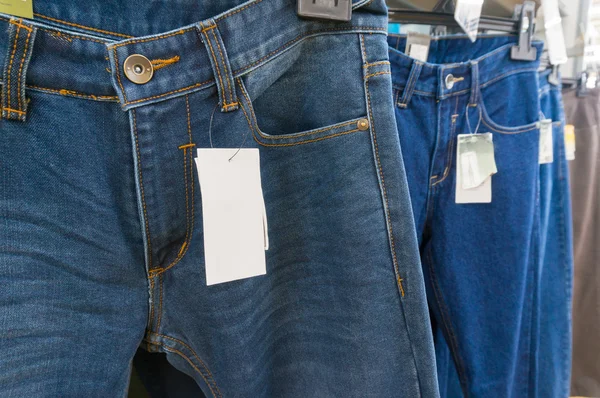 Prázdná bílá značka nad modré džíny na věšák police v Supermark — Stock fotografie