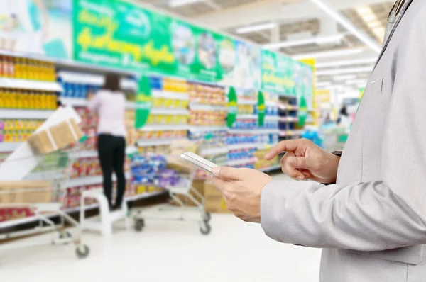 Mano de Empresario utilizar tableta móvil en el supermercado —  Fotos de Stock