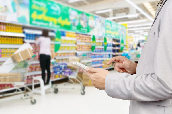 Hand of Businessman use Mobile Tablet in supermarket — Stock Photo, Image