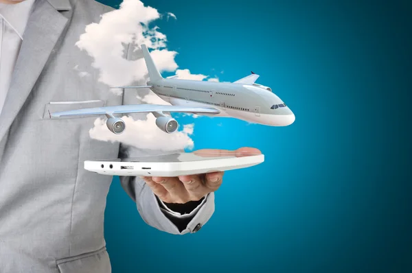 Biznes człowiek trzyma obecnie samolot tabletki w ręce — Zdjęcie stockowe
