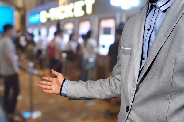 Geschäftsmann zeigt Willkommensgruß oder lädt Geste auf Kinokarte ein — Stockfoto