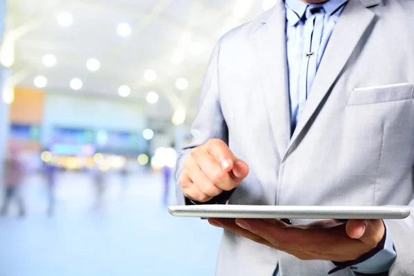 Handsome young man in shopping mall using mobile tablet