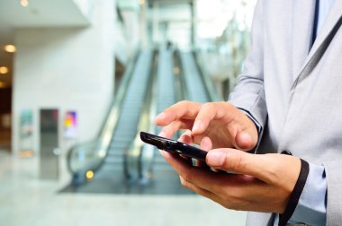 İş adam yürüyen merdivenle giderken mobil