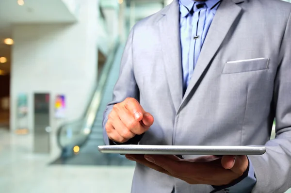 Geschäftsmann benutzt Tablet-PC in Bürohaus-Rolltreppe — Stockfoto