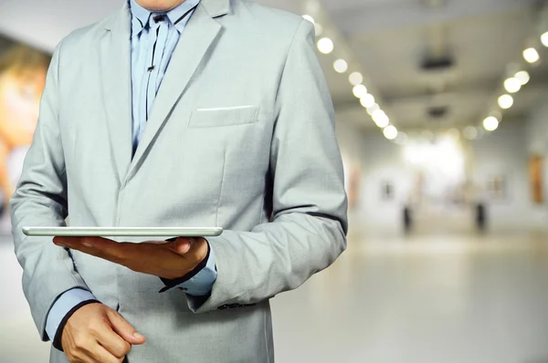 Business Man using Mobile Tablet in Gallery Art Center or Museum