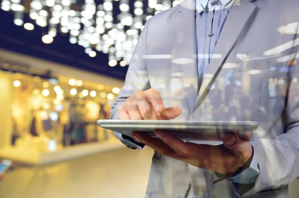 Alışveriş merkezinde mobil dijital Tablet kullanan iş adam. S