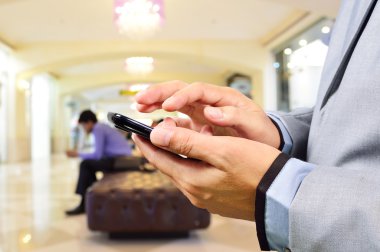 Business Man using Mobile Phone in Modern Building Hallway