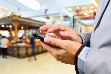 cep telefonunuzun ve modern alışveriş merkezinde iş adamı