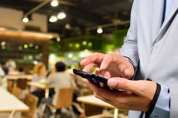 Homem de negócios usando telefone inteligente móvel em Restaurante ou Food Cour — Fotografia de Stock