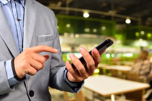 Hombre de negocios usando teléfono inteligente móvil en Restaurant o Food Cour — Foto de Stock