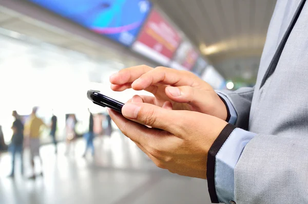 Geschäftsmann benutzt Handy in modernem Bahnhof — Stockfoto