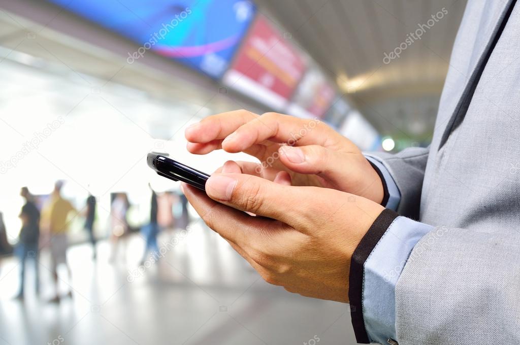 Business Man using Mobile Phone in Modern Train Station