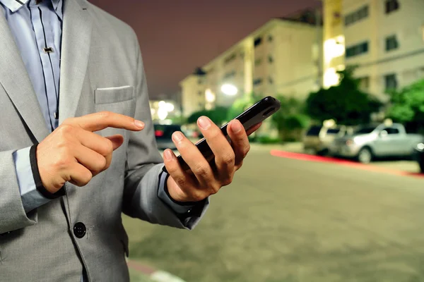 Ung affärsman använder mobiltelefon på gatan — Stockfoto