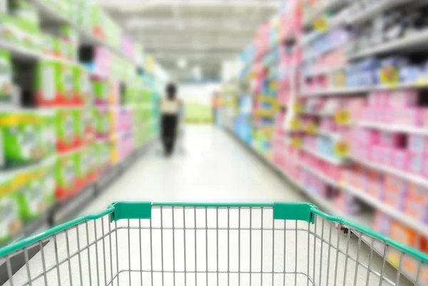 Carro de compras en el supermercado con la gente — Foto de Stock