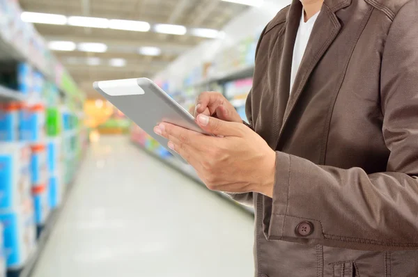 Jovem mãos segurando Tablet no supermercado — Fotografia de Stock