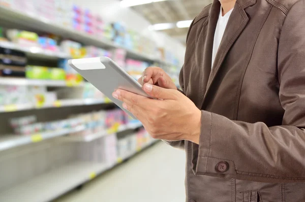 Genç adam Tablet süpermarkette holding eller