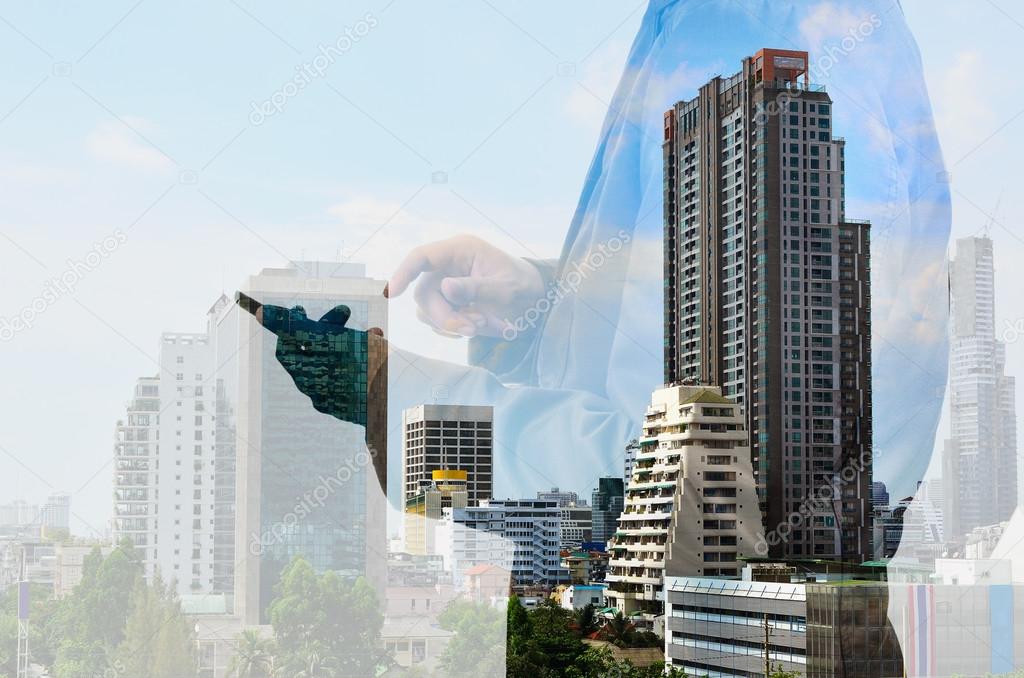 Double exposure of city and businessman with smartphone or mobil