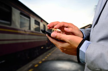 Boş demiryolu platformu üzerinde onun cep telefonu kullanan adam. Yakın çekim h