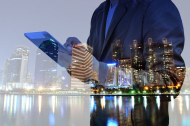 Dijital tablet kullanan şehir ve işadamının çifte pozu