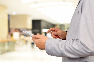 Modern işletme binası içinde Mobil Tablet kullanarak iş adamı.