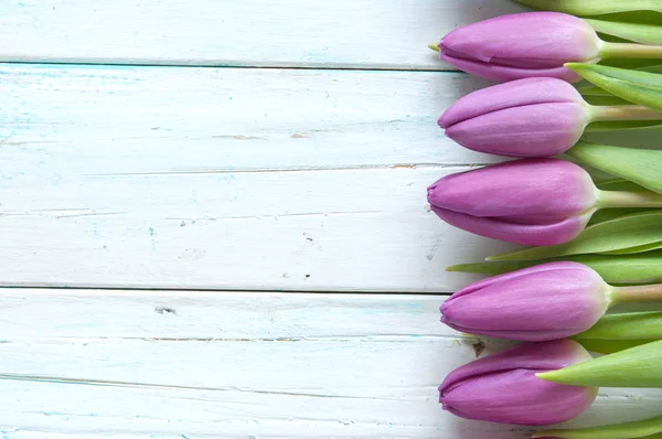 Tulipas roxas no fundo de madeira — Fotografia de Stock