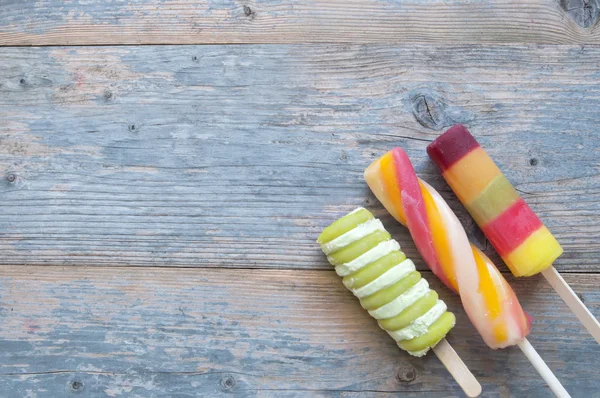 Ice lollies on a wooden background — Stock Photo, Image