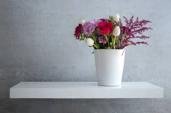 コンクリート壁に白い棚に浮かぶ春の花 — ストック写真